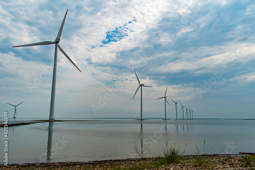 Modern windmills built on a narrow dam on the west coast of Denmark, Nissum Bredning Bay
