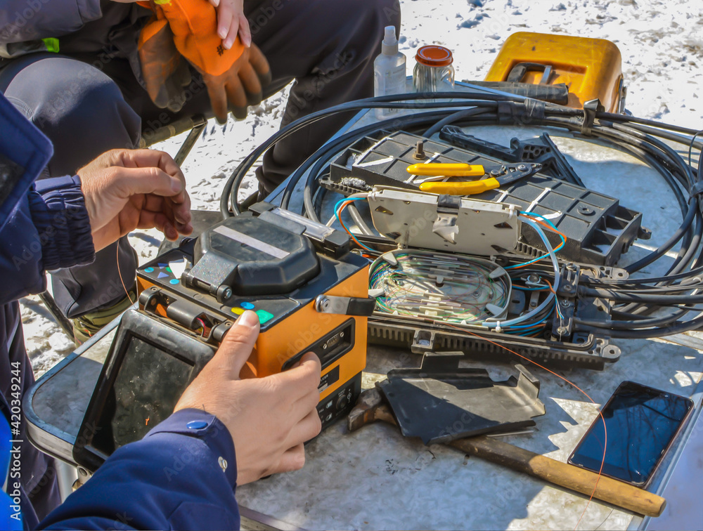 Hands of Internet cable repair workers.