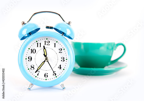 Blue alarm clock and a cup of coffee