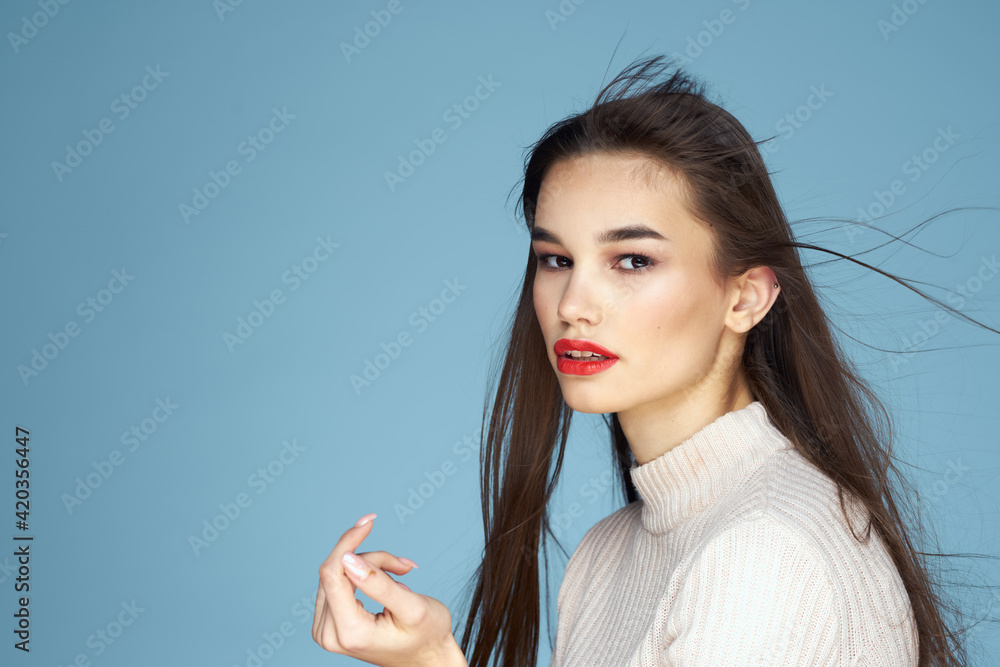 Pretty woman red lips white jacket attractive look close-up blue background Pretty woman red lips white jacket attractive look close-up blue background