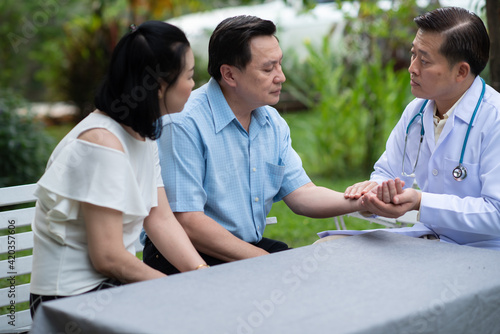 Professional doctor consulting asian senior couple patient at home  Health care service advisor. 