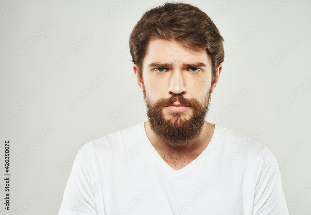 Bearded man in white T-shirt puzzled look sad face cropped look Bearded man in white T-shirt puzzled look sad face cropped look