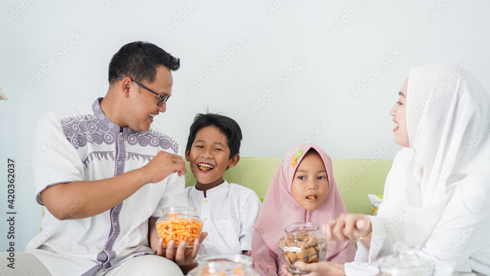 Asian Muslim families celebrate Eid together while enjoying a meal Asian Muslim families celebrate Eid together while enjoying a meal