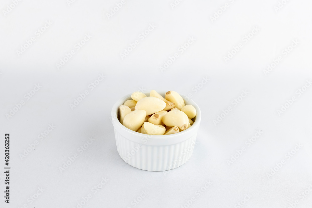 Closeup of a bowl full of garlics on white background Closeup of a bowl full of garlics on white background