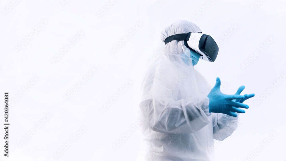 Naklejka premium Unrecognizable doctor with vr glasses and full protective uniform touching air with finger. Robotic surgery simulation. High quality photo