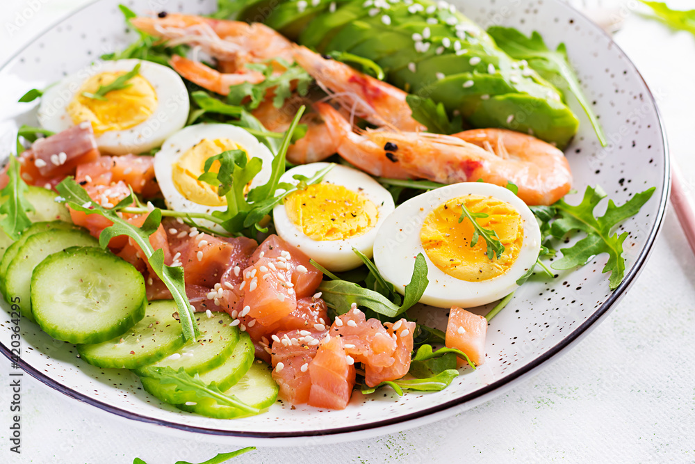 Ketogenic diet breakfast. Salt salmon salad with boiled shrimps, prawns, cucumbers, arugula, eggs and avocado. Keto, paleo lunch. Ketogenic diet breakfast. Salt salmon salad with boiled shrimps, prawns, cucumbers, arugula, eggs and avocado. Keto, paleo lunch.
