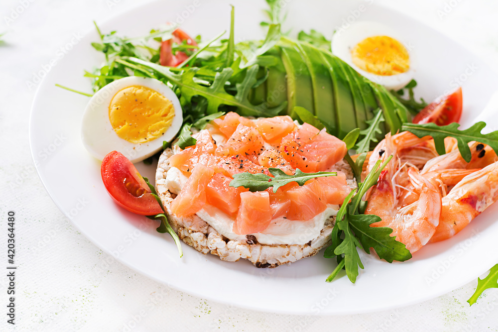 Ketogenic diet breakfast. Salt salmon salad with boiled shrimps, prawns, tomatoes, arugula, eggs and avocado. Keto, paleo lunch. Ketogenic diet breakfast. Salt salmon salad with boiled shrimps, prawns, tomatoes, arugula, eggs and avocado. Keto, paleo lunch.