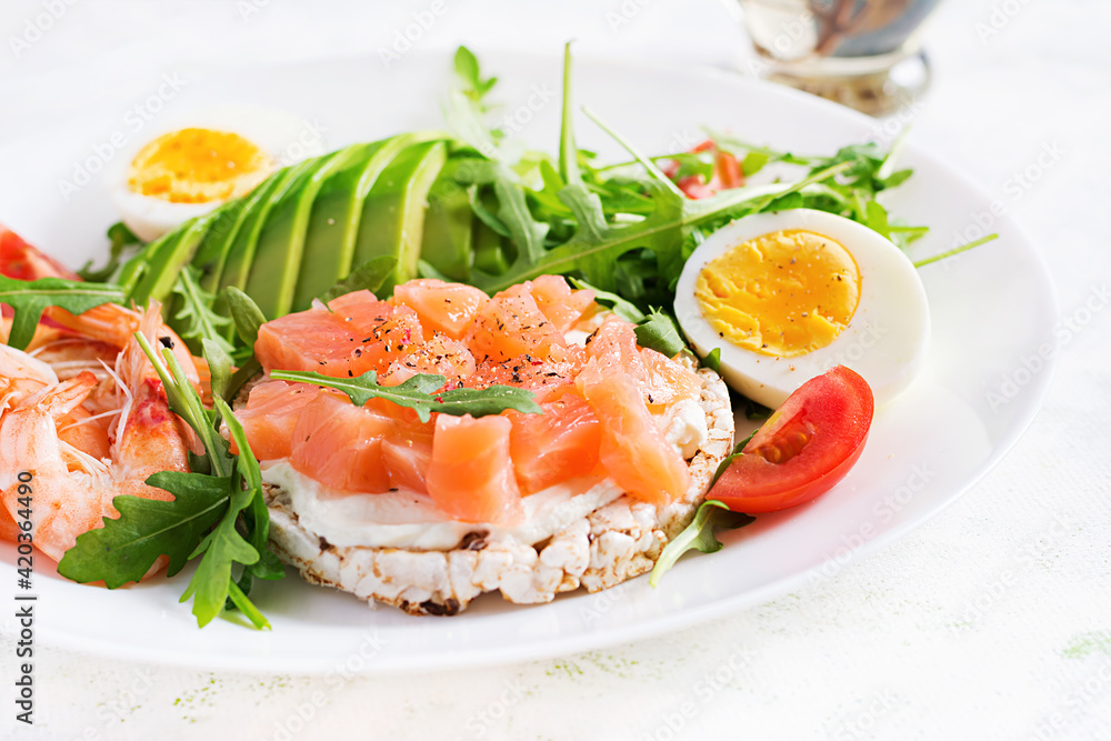 Ketogenic diet breakfast. Salt salmon salad with boiled shrimps, prawns, tomatoes, arugula, eggs and avocado. Keto, paleo lunch. Ketogenic diet breakfast. Salt salmon salad with boiled shrimps, prawns, tomatoes, arugula, eggs and avocado. Keto, paleo lunch.