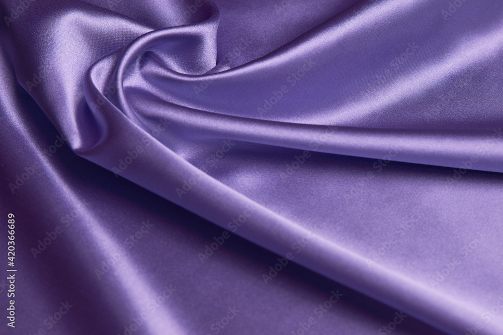 Fototapeta premium Purple silk fabric background, close-up. Smooth violet satin cloth texture