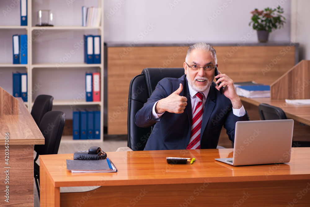 Old male employee sitting in the office Old male employee sitting in the office