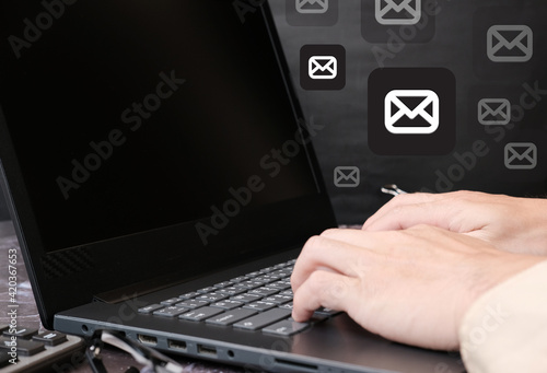 Businessman hand working on laptop computer and document management concept with icons on virtual screen