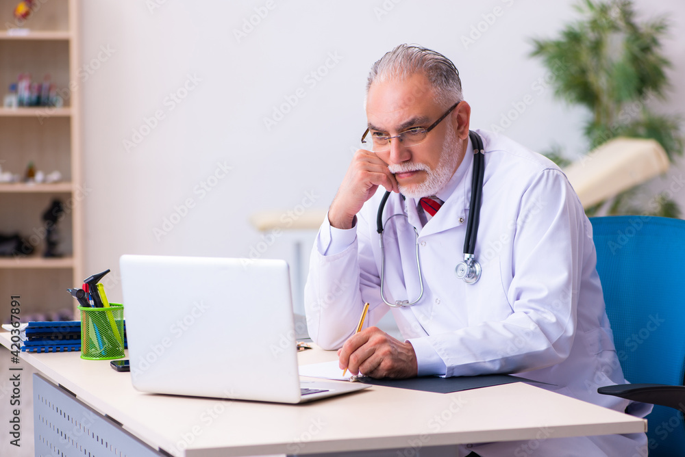 Old male doctor working in the clinic Old male doctor working in the clinic