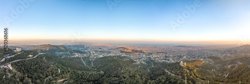 Panorama Aerial drone shot of Tibidabo Mountain with city view of Barcelona during sunset