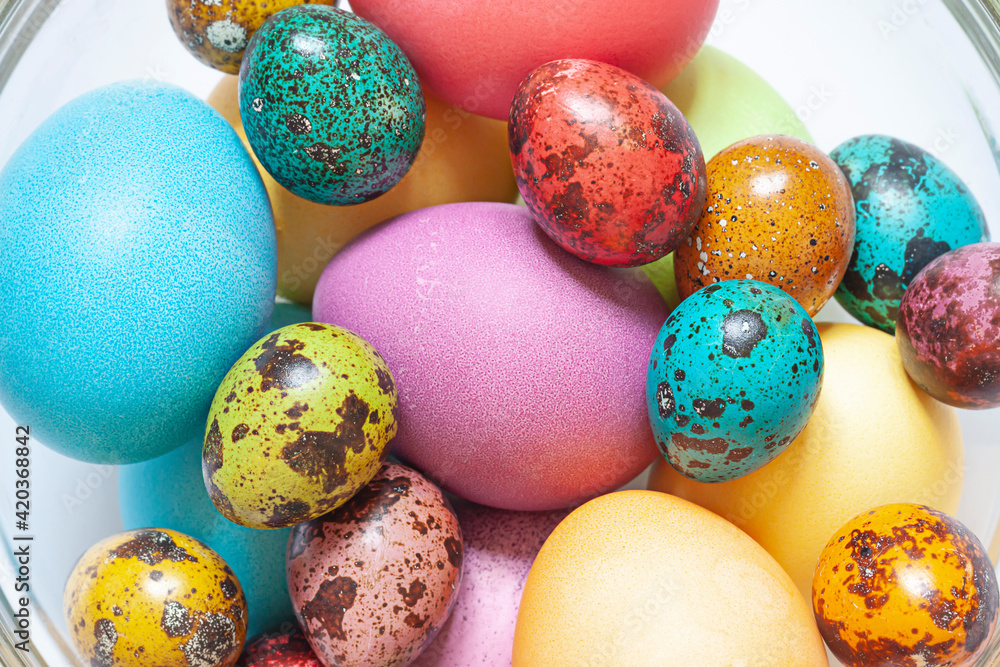 Colorful painted Easter eggs in the glass bowl on the white background. Close up Colorful painted Easter eggs in the glass bowl on the white background. Close up