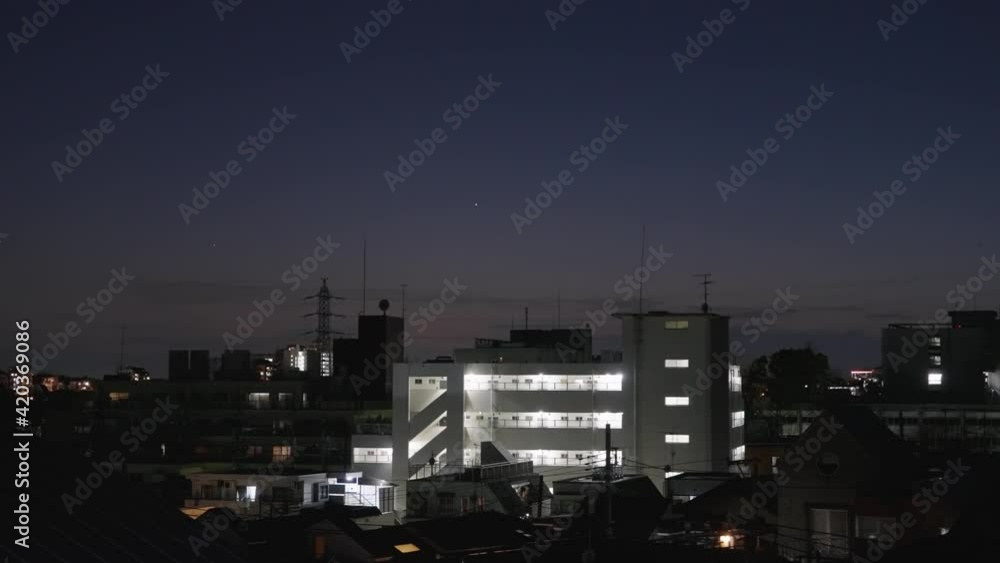 Jupiter And Saturn Great Conjunction Over Apartment House And Buildings In Tokyo, Japan. - wide static shot Jupiter And Saturn Great Conjunction Over Apartment House And Buildings In Tokyo, Japan. - wide static shot