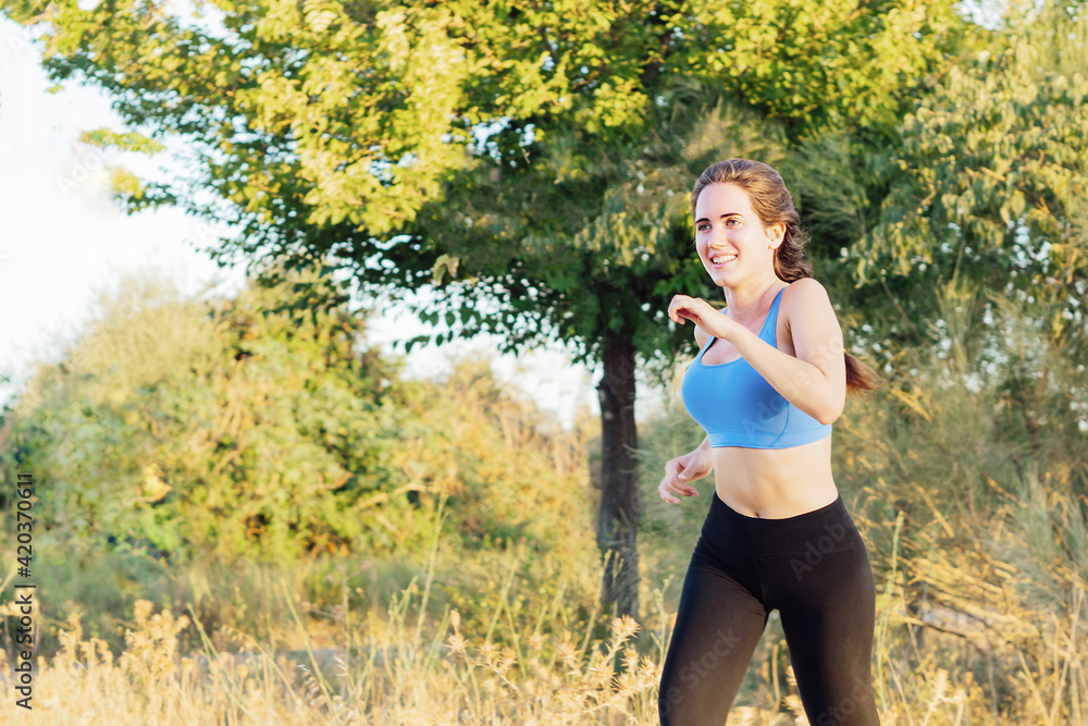 Young woman in sportswear running in the park Young woman in sportswear running in the park