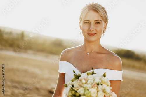 Photos Portrait of a beautiful blonde bride in a white dress with bare shoulders