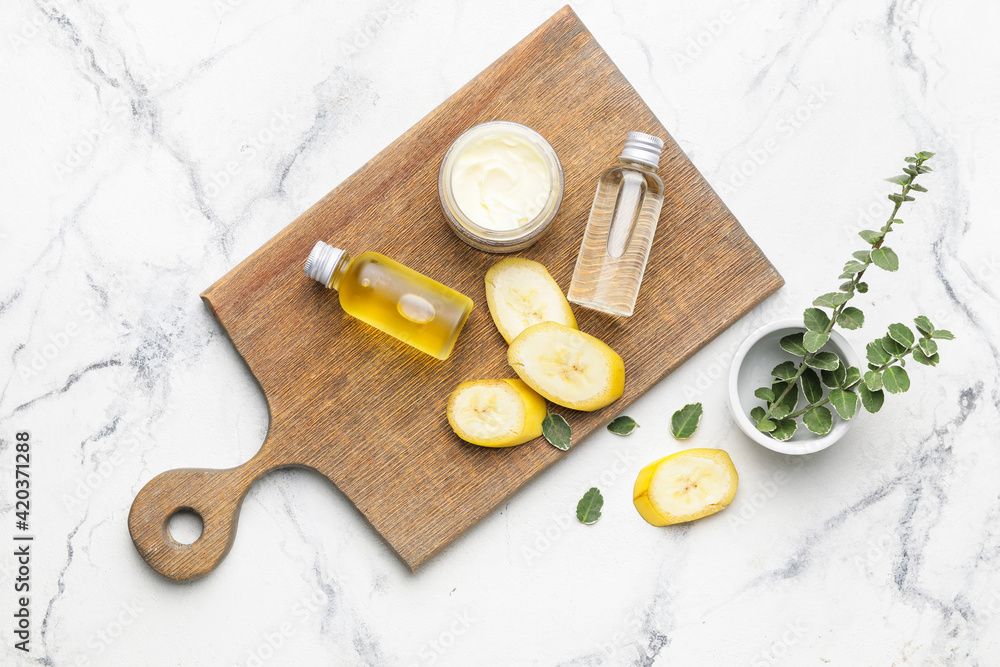Composition with banana cosmetics on light background Composition with banana cosmetics on light background