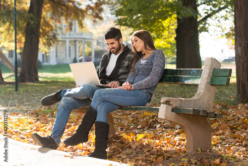Young Couple Using Laptop At Outdoor In Park