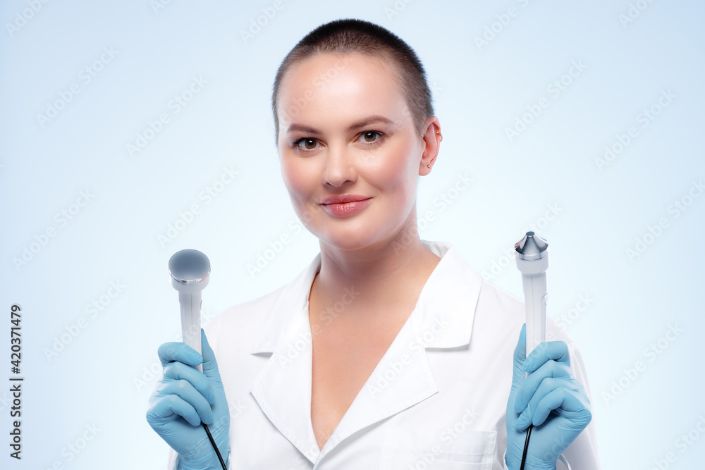 Portrait of a woman dermatologist holding cosmetic device attachment Portrait of a woman dermatologist holding cosmetic device attachment