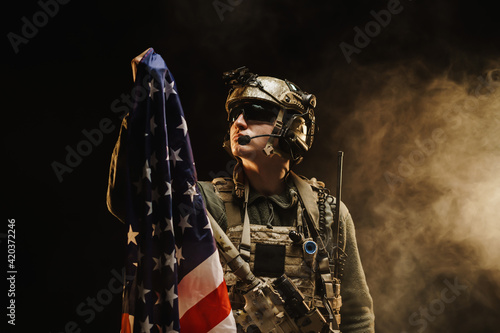 Konstfotografi Special forces soldier holding US national flag in the dark