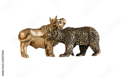 Isolated image of yellow metal bull and bear figurines. The concept of the symbol of stock trading, the interaction of buyers and sellers. A series of images. © mangz