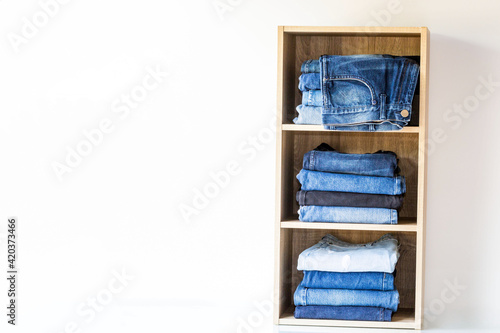 Jeans stack on the shelves in the store at supermarket.