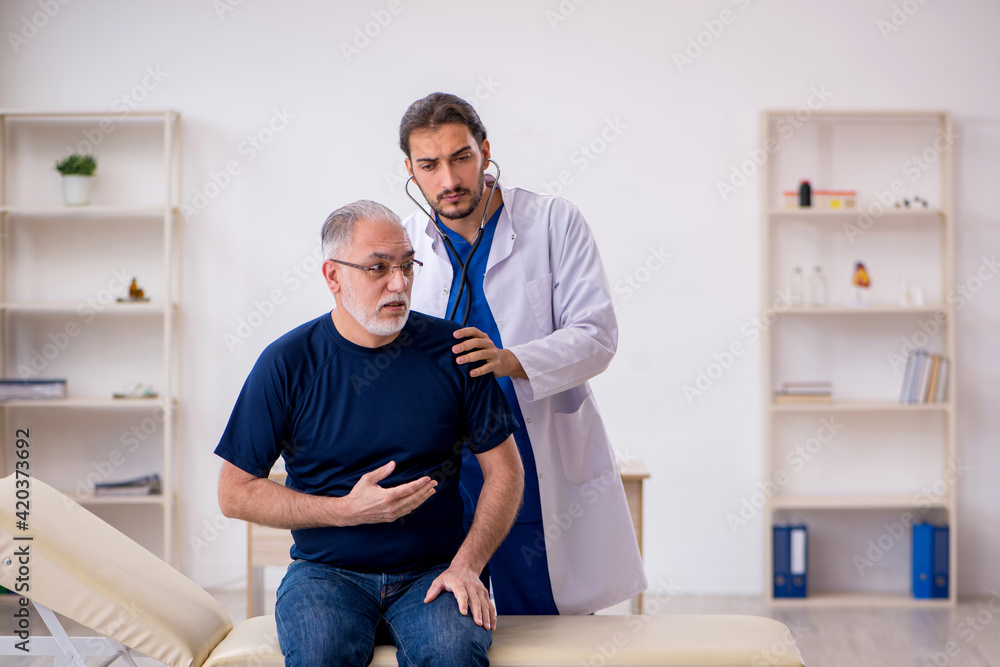 Old male patient visiting young male doctor Old male patient visiting young male doctor