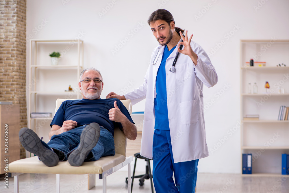 Fototapeta premium Old male patient visiting young male doctor chiropractor