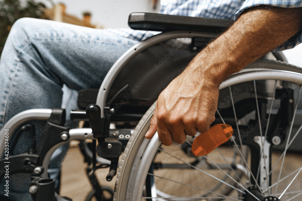 Unrecognizable disabled man sitting in a wheelchair Unrecognizable disabled man sitting in a wheelchair
