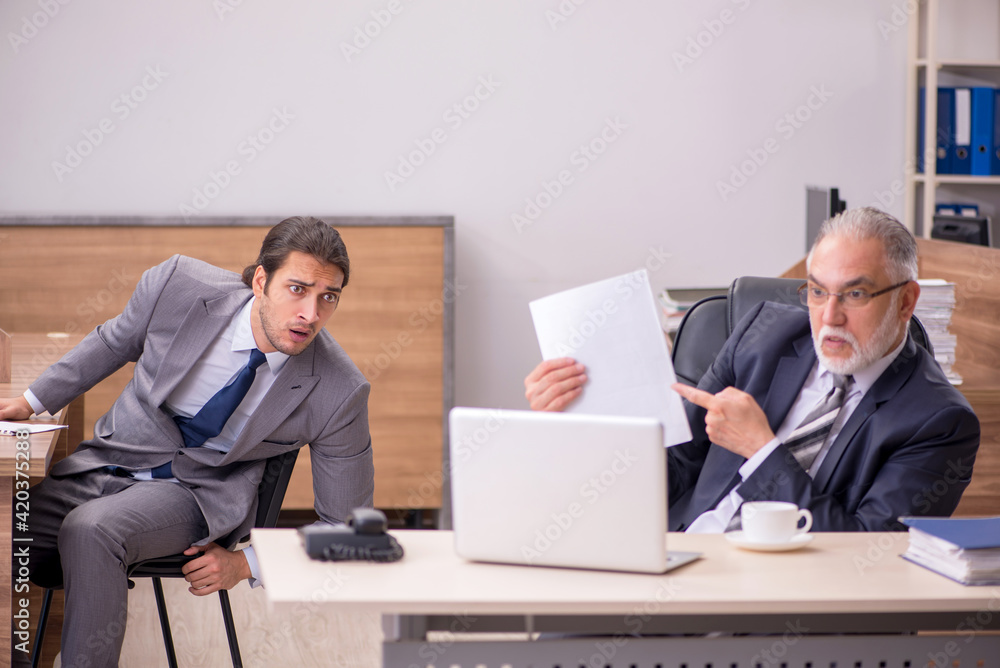 Old boss and young male assistant in the office