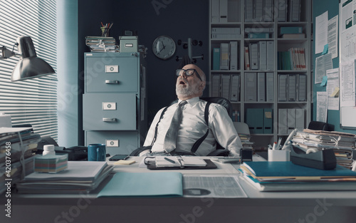 Lazy exhausted businessman napping in the office photo