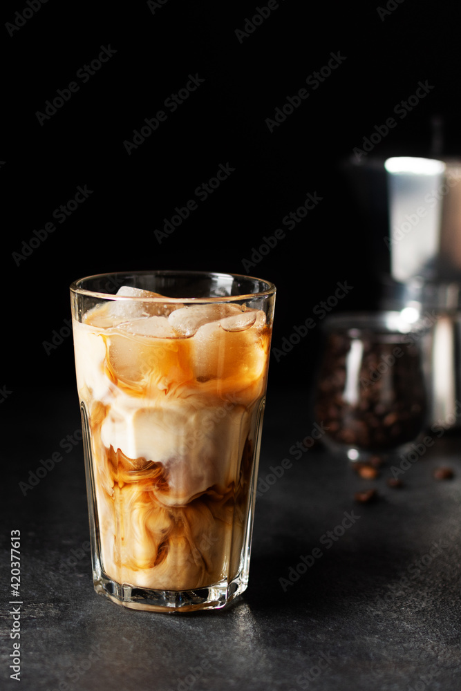 Iced coffee in a tall glass on black background. Iced coffee in a tall glass on black background.