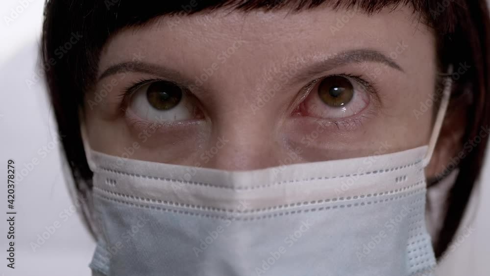 Young Girl in Mask Rotates Red, Bloodshot Eyes. Viral Conjunctivitis. Zoom Young Girl in Mask Rotates Red, Bloodshot Eyes. Viral Conjunctivitis. Zoom