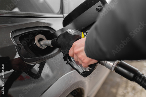 Male hand close-up refueling a black car