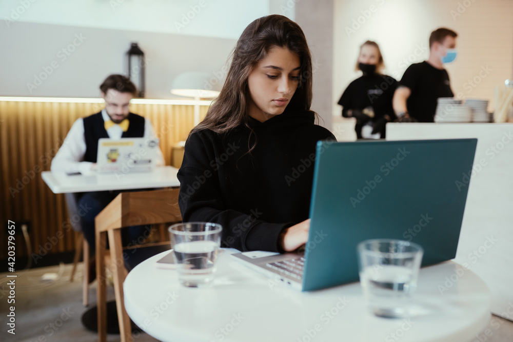 Portrait of female student using net-book while sitting in cafe Portrait of female student using net-book while sitting in cafe