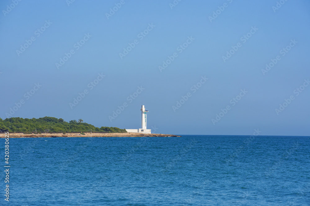 Modern lighthouse in the Mediterranean Sea. No clouds, blue sky, sunny day. 