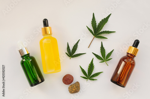 Marijuana leaves, cbd oil, cosmetic cream. Cannabis extract in cosmetology. Flat lay, powder background. Home relaxation, spa recreation, pastime therapy.