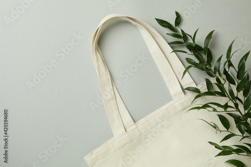 Eco bag and twig on light gray background photo