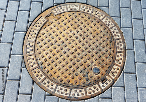Sewer manhole cover between blocks