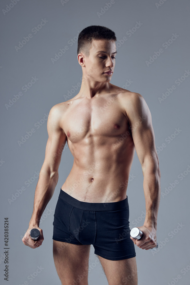 sporty man in black shorts with dumbbells in hands pumped up body posing exercise sporty man in black shorts with dumbbells in hands pumped up body posing exercise