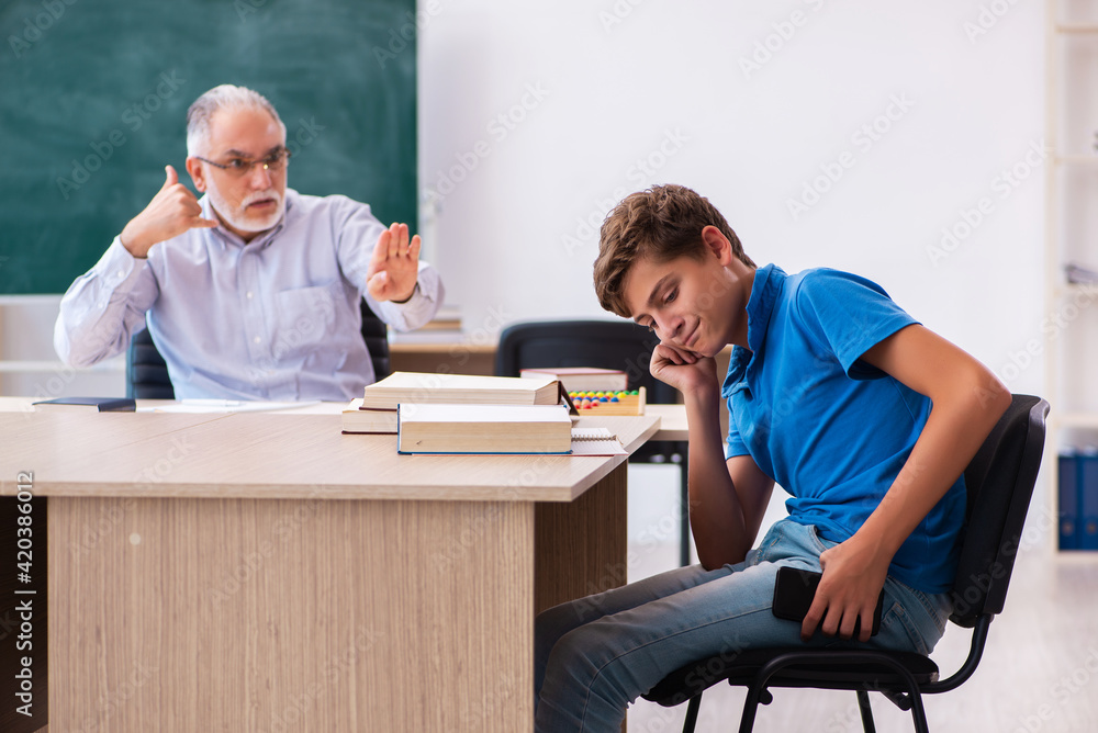 Old male teacher and schoolboy in the classroom Old male teacher and schoolboy in the classroom