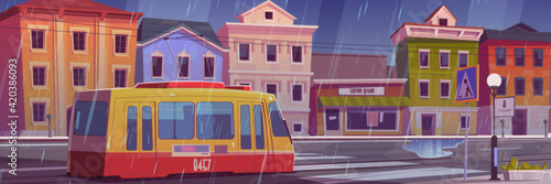 Rain on city street with houses and tram