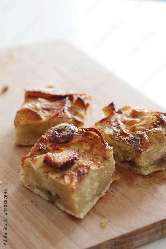 pieces of homemade apple pie with cinnamon on wooden board pieces of homemade apple pie with cinnamon on wooden board