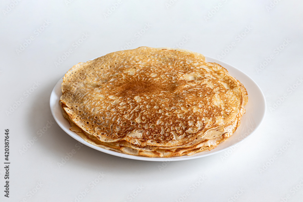 Thin pancakes with a crisp crust on a white plate