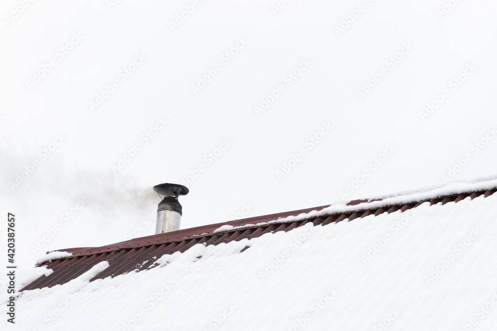 The chimney smokes on the roof of the house The chimney smokes on the roof of the house