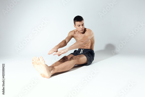 man doing sports exercises while sitting on the floor indoors
