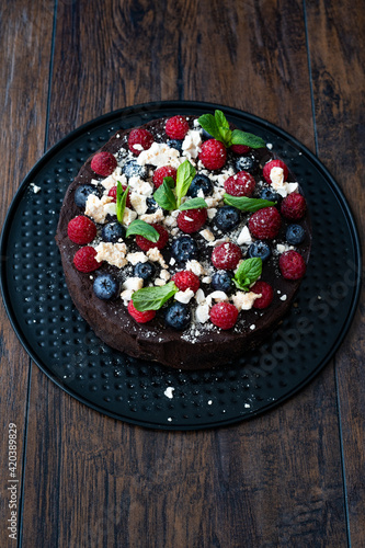 Chocolate Raw Cake with Raspberries, Blueberries, Meringue and Mint Leaves.