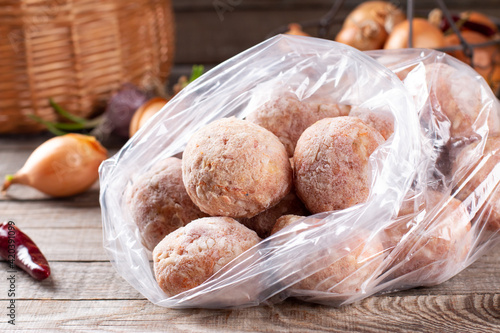 Plastic bags with frozen meat and meatballs in plastic bag on a table photo