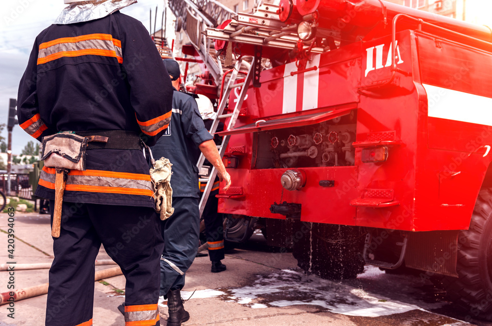 Fototapeta premium red fire truck with a ladder at sunset.